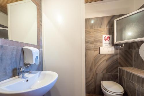 a bathroom with a sink and a toilet and a mirror at Alessandro Palace & Bar in Rome