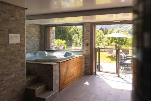 a bathroom with a tub and a sliding glass door at Chalet Adelphine 1 & SPA in Les Gets