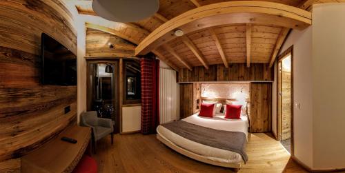 a bedroom with a bed in a room with wooden ceilings at Chalet Adelphine 1 & SPA in Les Gets