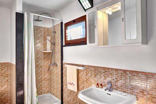 a bathroom with a sink and a mirror at GOCCE VILLAS - Il Frantoio in Massa Lubrense