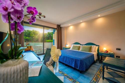 a bedroom with a blue bed and a balcony at Villaggio Giardini D'Oriente in Nova Siri Marina