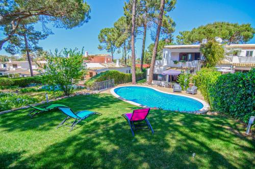 a yard with two chairs and a swimming pool at Villa Beira Golf by Algarve Holidays in Quarteira