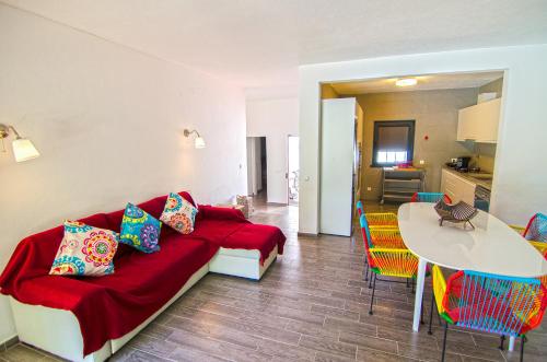 a living room with a red couch and a table at Villa Beira Golf by Algarve Holidays in Quarteira