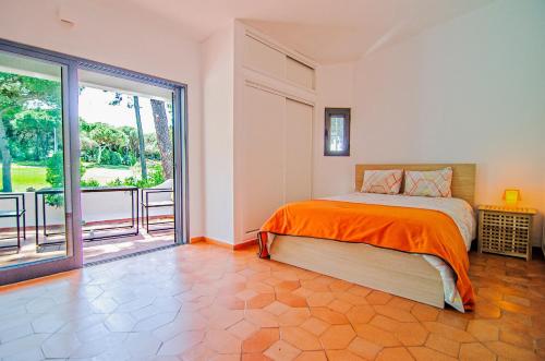 a bedroom with a bed and a large window at Villa Beira Golf by Algarve Holidays in Quarteira