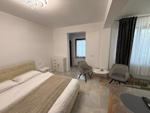 a bedroom with a bed and two chairs and a table at visitor's house 5 in Rădăuţi