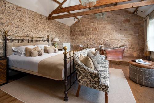 a bedroom with a bed and a stone wall at Beadnell Towers Hotel in Beadnell