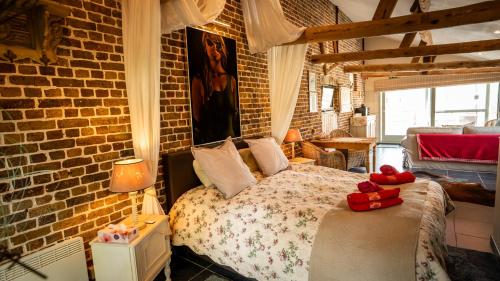 a bedroom with a bed and a brick wall at B&B Hoeve Westdijk in Oostkamp