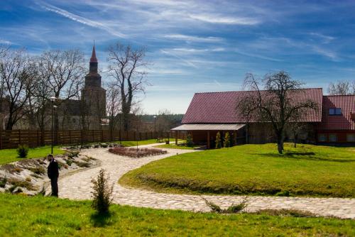 un hombre parado en un camino delante de una iglesia en Gospodarstwo Kochańscy, en Stargard