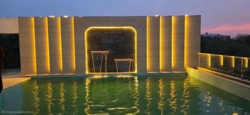 a building with a pool of water with lights at Hotel Waterlily in Indore