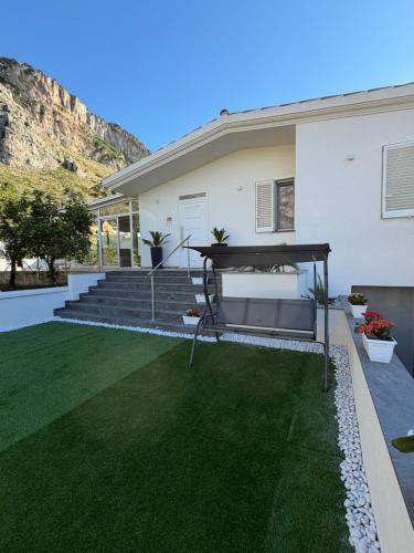 a house with a bench in the yard at Villa Amelia in Capaci