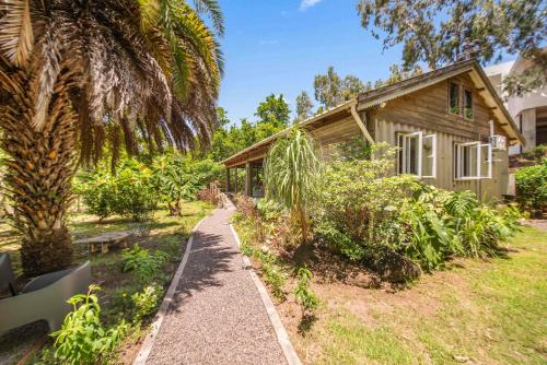 a path leading to a house with a palm tree at Canopy Lodge - Perfect Mauritius Trip in Tamarin