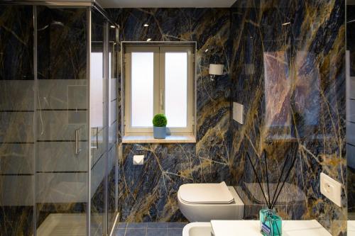 a bathroom with a toilet and a window at Casale Gli Ulivi in Orbetello
