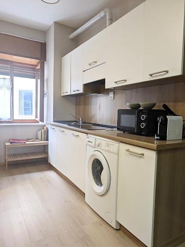 a kitchen with a washing machine and a microwave at Bosco Verde in Tarvisio