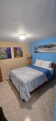 a bedroom with a large bed with blue walls at Exotic Paradise Guest House in Yabucoa