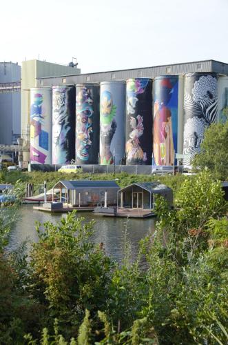 a building with a bunch of signs on it at Wikkelboats at Tramkade Den Bosch in Orthen