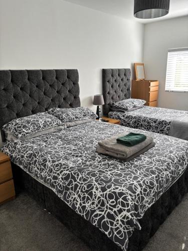 a bedroom with two beds and a large headboard at Evas place in Llandudno