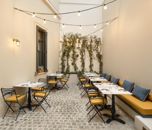 a row of tables and chairs in a dining room at Ergon House Ermou in Athens