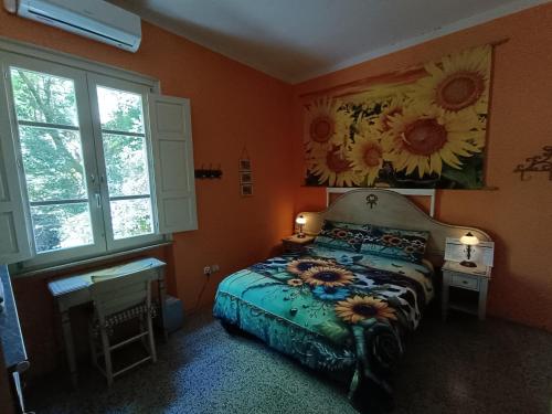 a bedroom with a bed and a painting of sunflowers at B&B Candalla in Camaiore