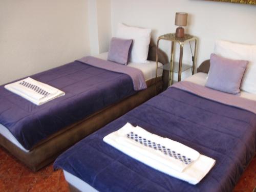 two beds in a room with purple sheets and pillows at Apartment Yasica 2 in Izačić
