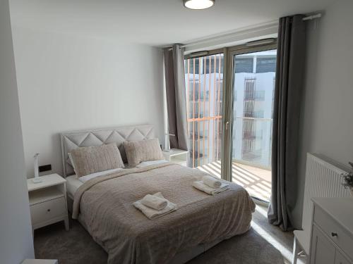 a bedroom with a bed with two towels on it at PINEA 2 BEDROOM APARTMENT WITH Sea VIEW in Pobierowo