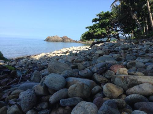 a pile of rocks on a beach near the water at Paradise Palms in Ko Chang