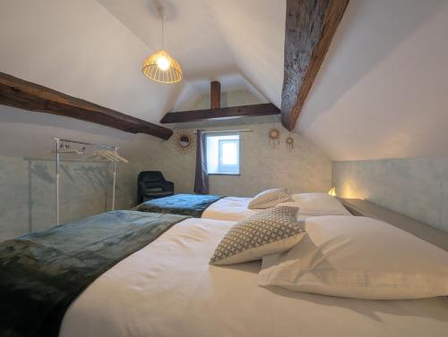 a bedroom with a large bed with two pillows at Gîte simone de beauvoir in Châteauvillain