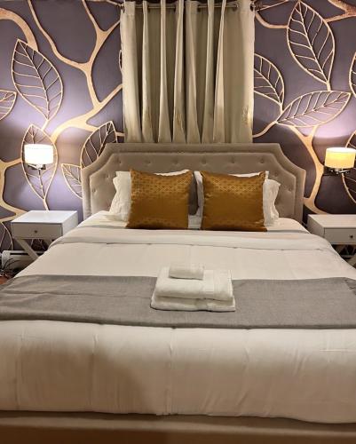 a bedroom with a large bed with a purple wall at Spacious 4BR Near Subway, Sleeps 8per Easy Access to Downtown Boston in Boston