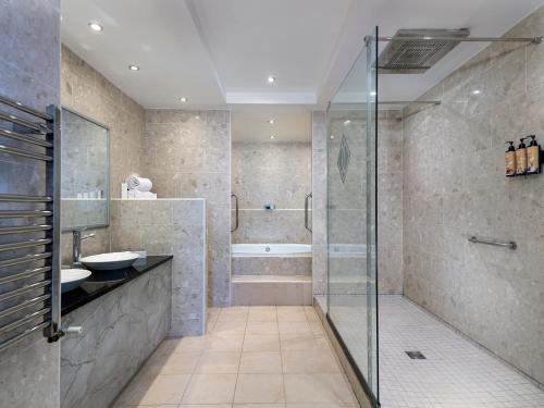 a bathroom with a shower and a sink and a tub at Diamond Coast Hotel in Enniscrone