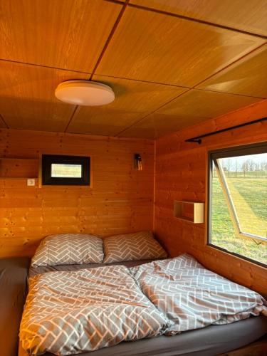 a bed in a small room with a window at Mája u lomu in Stachlovice