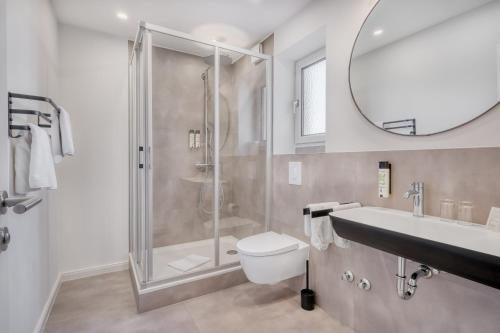 ein Badezimmer mit Dusche, Toilette und Waschbecken in der Unterkunft Hotel Bad Minden in Minden