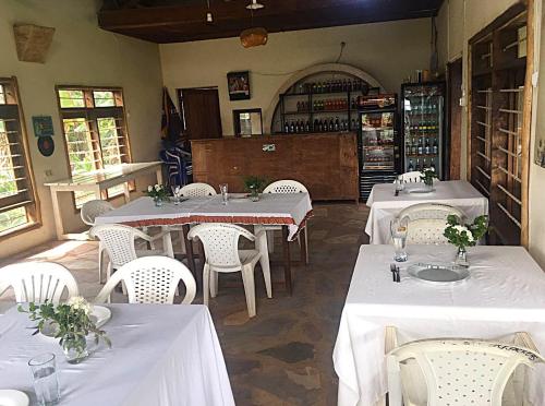 a restaurant with white tables and white chairs at Masaka Backpackers, Tourists Cottage & Campsite in Masaka