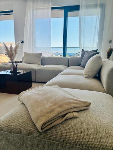 a living room with a couch with pillows on it at Penthouse Jacuzzi SeaView Suite in Makarska