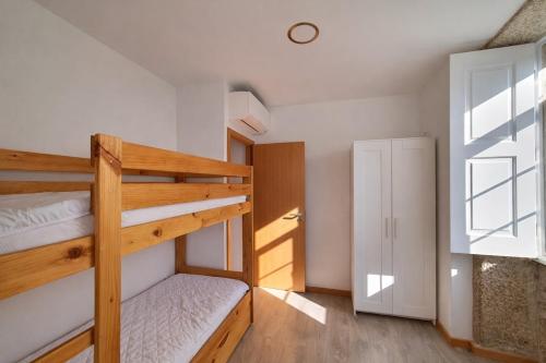 a bedroom with two bunk beds and a window at Refugio dos Coviais in Guarda