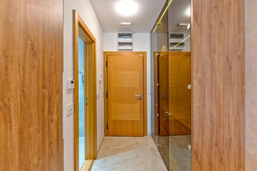 a hallway with two wooden doors and a room with a floor at Vila Pino Silvestre in Zlatibor