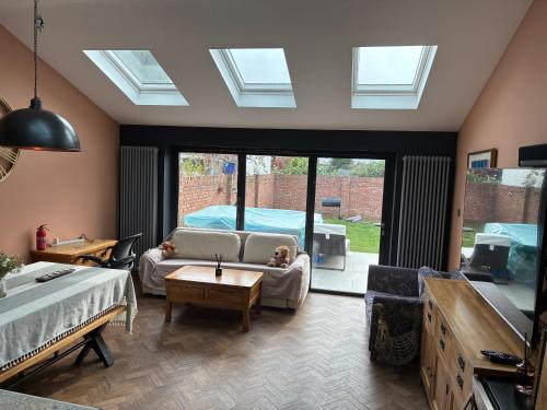 a living room with a couch and a table at 4 bed house close to Allianz Stadium, LHR and London 20mins away in Hounslow