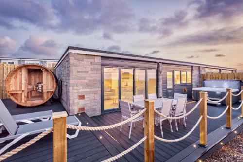 a deck with a table and chairs and a barrel at North Devon Resort in Ilfracombe