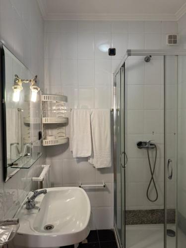 a white bathroom with a shower and a sink at Residencial Deu-La-Deu by Hotel Dom Afonso in Monção
