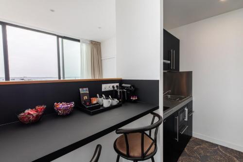 a kitchen with a counter and a stool in a room at Le Barracuda & Spa, pieds dans l'eau, vue mer, espace bien-être offert in Brest