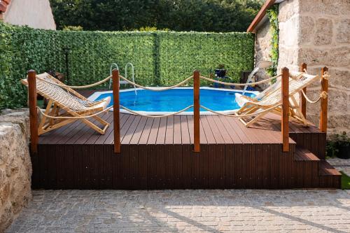 two chairs and a hammock next to a pool at Refugio dos Coviais in Guarda