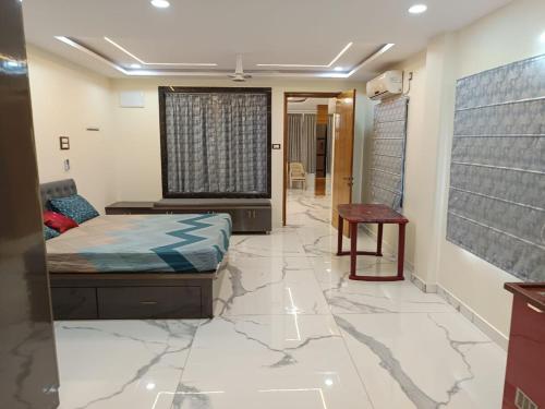 a bedroom with a bed and a table on a marble floor at Ganesh Nilayam in Hyderabad
