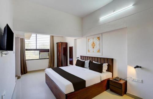 a bedroom with a large bed and a television at Hotel Vijai Square in Prayagraj