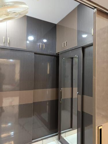a row of black cabinets with glass doors in a room at Ganesh Nilayam in Hyderabad