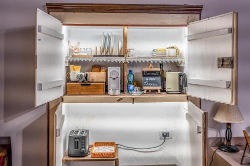 a small kitchen with white cabinets and appliances at Casa Lanzara - Dimora Storica nel cuore del Pollino in Morano Calabro