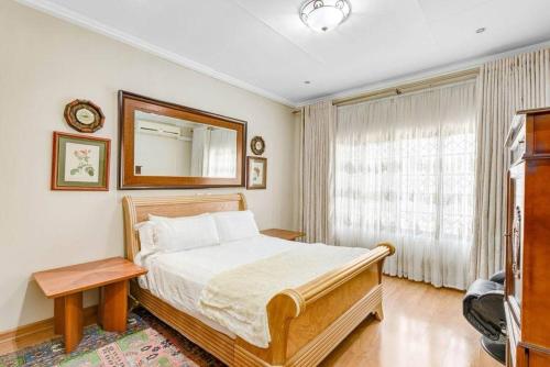 a bedroom with a bed and a mirror on the wall at The Adress beautiful in Midrand
