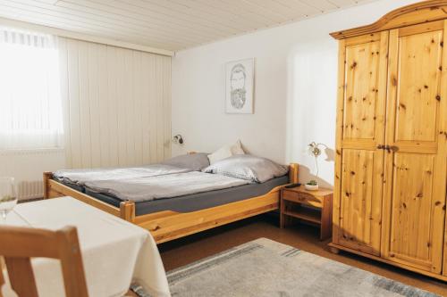 a bedroom with a bed and a wooden cabinet at Ferienlodge bei den Reben in Sankt Margarethen im Burgenland
