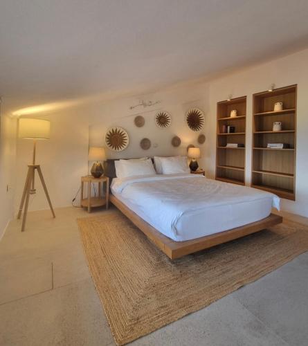 a bedroom with a large white bed and two lamps at Villa Musa with private pool in Afitos
