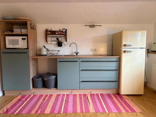 a kitchen with a refrigerator and a kitchen rug at Ferienwohnung Schatzkisterl in Wörth