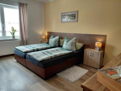 ein Schlafzimmer mit einem Bett mit hölzernem Kopfteil in der Unterkunft Doppelappartement CityImmo in Gotha