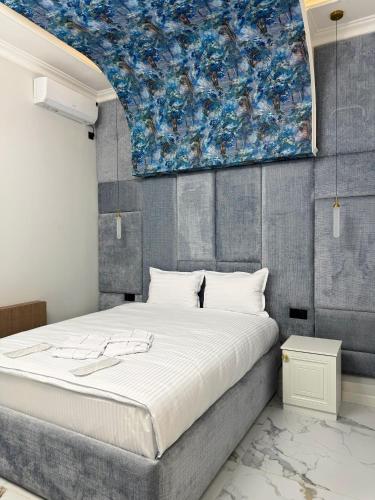 a bedroom with a large bed with a painting on the wall at Shahzam Hotel in Samarkand