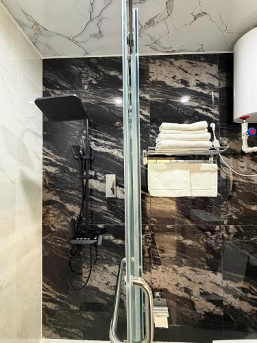 a glass shower in a bathroom with a pile of towels at Shahzam Hotel in Samarkand
